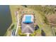 An aerial view highlighting the neighborhood pool and clubhouse facilities by a lake at 3675 Cabo Ln, St Cloud, FL 34772