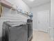 Bright laundry room with washer, dryer, tile floors, and overhead storage at 3675 Cabo Ln, St Cloud, FL 34772