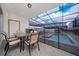 Screened-in patio with dining table and chairs and a view of the pool area at 4002 Lana Ave, Davenport, FL 33897