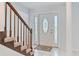 Bright foyer with tile flooring, decorative front door, staircase, and natural light streaming through a window at 4531 Lake Trudy Dr, St Cloud, FL 34769