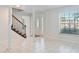 Bright foyer with tile flooring, decorative front door, staircase, and natural light streaming through a window at 4531 Lake Trudy Dr, St Cloud, FL 34769