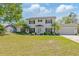 Charming two-story home with a well-manicured lawn, mature landscaping, and a classic white exterior at 4531 Lake Trudy Dr, St Cloud, FL 34769