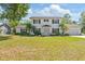 Charming two-story home with a well-manicured lawn, mature landscaping, and a classic white exterior at 4531 Lake Trudy Dr, St Cloud, FL 34769