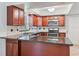 Modern kitchen featuring dark wood cabinetry, granite countertops, stainless steel appliances, and ample counter space at 4531 Lake Trudy Dr, St Cloud, FL 34769