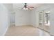 Bright living room featuring tile floors, ceiling fan, and sliding glass doors to the screened patio at 4531 Lake Trudy Dr, St Cloud, FL 34769