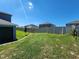 Fenced backyard featuring a well maintained lawn and a young tree at 474 Annabelle Way, Davenport, FL 33837