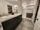 Bright bathroom featuring a double sink vanity, a glass enclosed shower, and tile flooring at 474 Annabelle Way, Davenport, FL 33837