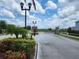 Gated community entrance with decorative street lamps, landscaping and brick pillars at 474 Annabelle Way, Davenport, FL 33837