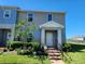 Charming two-story home with landscaped yard, brick pathway, and covered entrance at 474 Annabelle Way, Davenport, FL 33837