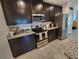 Well-equipped kitchen with stainless steel appliances, granite countertops, and dark wood cabinets at 474 Annabelle Way, Davenport, FL 33837