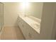 Bathroom features double sinks, white cabinets, and tile flooring at 4881 Vellacito Way, Davenport, FL 33897