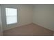 Bedroom featuring neutral carpet, large window with blinds, and white walls at 4881 Vellacito Way, Davenport, FL 33897