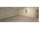 Garage features a metal garage door, white block walls and concrete floor at 4881 Vellacito Way, Davenport, FL 33897