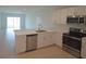 Modern kitchen featuring white cabinetry, stainless steel appliances, and an island sink at 4881 Vellacito Way, Davenport, FL 33897