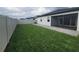 Large backyard with green grass, screened in porch, and private fence at 4952 Shady Pines Dr, St Cloud, FL 34772