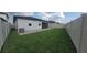 Spacious backyard featuring lush green grass, a paved patio, and privacy fencing at 4952 Shady Pines Dr, St Cloud, FL 34772