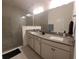 Bathroom featuring double sink vanity, framed mirrors, and a glass shower at 4952 Shady Pines Dr, St Cloud, FL 34772