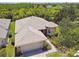 An aerial view of a one-story home with a two-car garage and lush landscaping at 531 Barcelona Dr, Poinciana, FL 34759