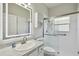 Bathroom featuring updated vanity with decorative mirror and walk-in shower with glass doors at 531 Barcelona Dr, Poinciana, FL 34759
