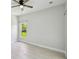 An empty bedroom with neutral walls, a ceiling fan, and modern wood look tile at 531 Barcelona Dr, Poinciana, FL 34759