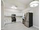 Contemporary kitchen featuring white cabinetry, marble countertops, and stainless steel appliances at 531 Barcelona Dr, Poinciana, FL 34759