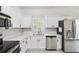 Well-lit kitchen with white cabinets, marble countertops, and stainless steel appliances for modern convenience at 531 Barcelona Dr, Poinciana, FL 34759