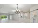 Open-concept living space featuring tile floors, an elegant chandelier, and a glimpse into the kitchen at 531 Barcelona Dr, Poinciana, FL 34759