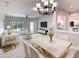 Staged living and dining area with white furniture, tile floors, and a modern chandelier at 531 Barcelona Dr, Poinciana, FL 34759