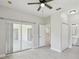 Bright main bedroom featuring a ceiling fan, tile flooring, and sliding glass doors to the outdoor patio at 531 Barcelona Dr, Poinciana, FL 34759