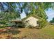 Rear view of home featuring a covered patio, mature trees, and lush yard at 541 Rebecca Dr, St Cloud, FL 34769