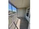 View of balcony with wood floors, white railings and utility closet; also shows building exterior at 6148 Westgate Dr # 302, Orlando, FL 32835