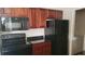 Kitchen with granite countertops, black appliances, and wooden cabinetry at 6148 Westgate Dr # 302, Orlando, FL 32835