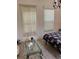 Cozy bedroom featuring wood-look floors, a floral comforter, and natural light from bright windows at 619 Tapatio Ln, Kissimmee, FL 34759