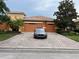 Charming home with a red tile roof, brick driveway and a well-manicured lawn at 619 Tapatio Ln, Kissimmee, FL 34759