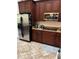 Modern kitchen with stainless steel refrigerator and appliances surrounded by brown cabinets at 619 Tapatio Ln, Kissimmee, FL 34759