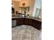 Well-lit kitchen with brown cabinets, granite countertops, stainless steel appliances, and tile floors at 619 Tapatio Ln, Kissimmee, FL 34759