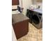 Laundry room with side-by-side washer and dryer and dark cabinets at 619 Tapatio Ln, Kissimmee, FL 34759