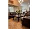 Inviting living area with tile flooring, leather sofas, large windows and adjacent dining area at 619 Tapatio Ln, Kissimmee, FL 34759