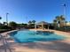 Community swimming pool surrounded by palm trees and a gazebo, perfect for relaxation and recreation at 642 Riggs Cir, Davenport, FL 33897