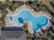 Aerial view of the winding community pool with a splash zone, shaded lounging, and lush landscaping at 709 Blackstone St, Minneola, FL 34715
