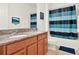 Bathroom with double sinks, granite counters, stylish mirrors, and a shower/tub with decorative curtain at 709 Blackstone St, Minneola, FL 34715