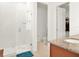 Bathroom featuring white tiled walk-in shower with glass and a wood vanity at 709 Blackstone St, Minneola, FL 34715