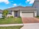 Inviting single-story house with a brick driveway, attached two-car garage, and neatly kept front yard at 709 Blackstone St, Minneola, FL 34715