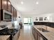Open concept kitchen with stainless steel appliances, island with sink, and sliding glass doors to the outdoor patio at 709 Blackstone St, Minneola, FL 34715