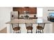 Kitchen island features stone countertop with bar stool seating and stainless steel appliances at 709 Blackstone St, Minneola, FL 34715
