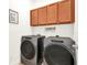 Laundry room with cabinets above a washer and dryer with a laundry themed sign at 709 Blackstone St, Minneola, FL 34715