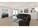 Comfortable living room featuring tile flooring, sliding glass doors, and a plush gray sofa at 709 Blackstone St, Minneola, FL 34715