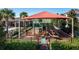 Community playground features a shady covering, climbing structures, slides, and shady seating nearby at 709 Blackstone St, Minneola, FL 34715
