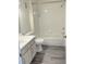 Bathroom featuring shower tub combo, vinyl flooring, single sink vanity, and white toilet at 7240 Westpointe Blvd # 1122, Orlando, FL 32835