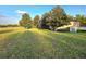 Scenic view of condo building on grassy area with mature trees and blue door at 7240 Westpointe Blvd # 1122, Orlando, FL 32835
